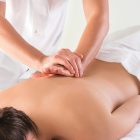 The picture of beautiful woman in massage salon and male hands close up